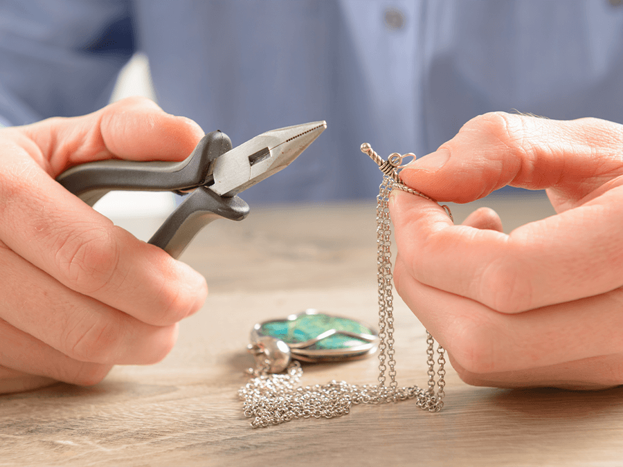 Man repairing jewelry silver chain with pliers - Breese, IL