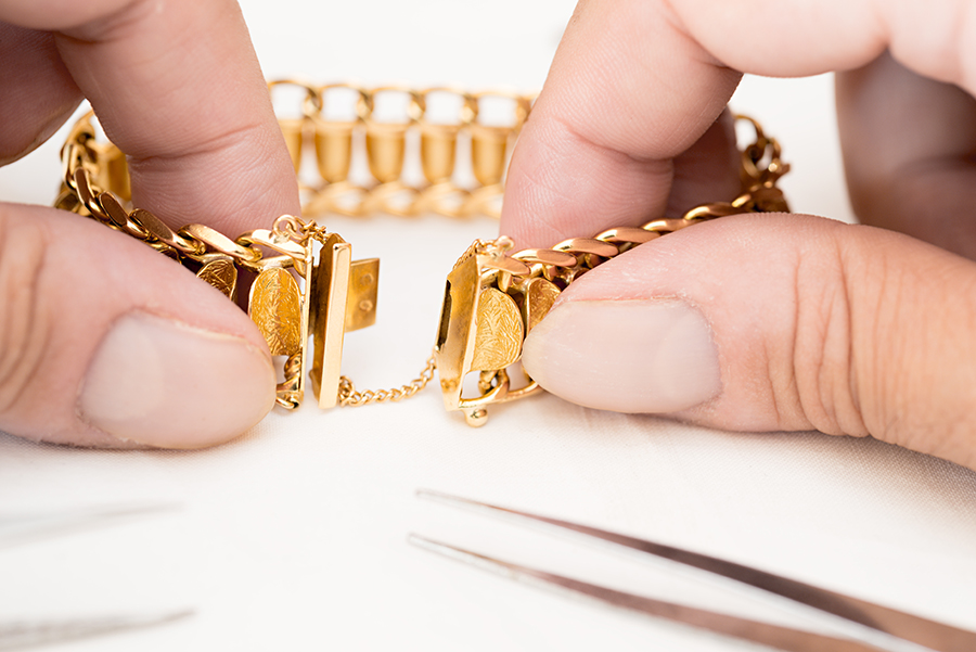 jeweler repairing clasp of gold bracelet - Highland, IL